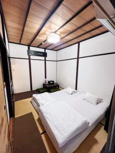 泉佐野比格汉姆之家住宿加早餐旅馆的卧室配有白色的床