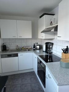 卡塞尔Kassel Apartment am Entenanger的厨房配有白色橱柜和黑色家电
