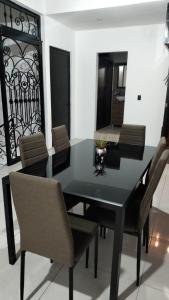 Juchitán de ZaragozaLidxi Stagabeñe的一张黑色餐桌,配有椅子和镜子