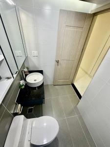 胡志明市Scenic Valley Suite的白色的浴室设有卫生间和水槽。