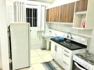 皮拉西卡巴Apartamento Privado - 2 quartos, varanda, sala e cozinha integrada的白色的厨房配有水槽和冰箱