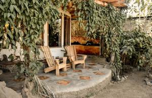 圣佩德罗拉拉古纳Bambuddha - Garden Suite at Lakehouse的房子前面的两把椅子和一张桌子