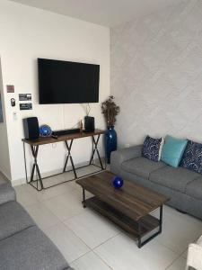 拉巴斯Casa Completa con Alberca privada的客厅配有沙发和带电视的桌子