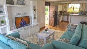 迪亚尼海滩Casa Marabella A2的客厅配有蓝色的沙发和电视