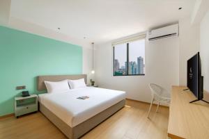 广州岭舍创享公寓酒店广州海珠店的卧室配有白色的床和电视。