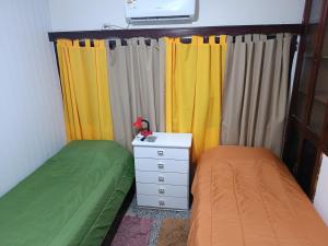 弗赖本托斯Suculento Apart的一间卧室配有两张床、一个梳妆台和窗帘