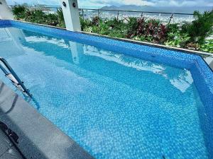 岘港ViAn Hotel And Spa Danang的蓝色的游泳池,背景是大海
