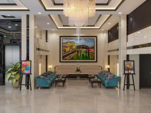 岘港ViAn Hotel And Spa Danang的大堂配有桌椅和绘画作品