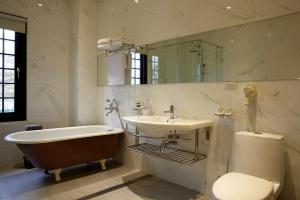 Nan-p'ing-li何留 Resort的带浴缸、盥洗盆和卫生间的浴室