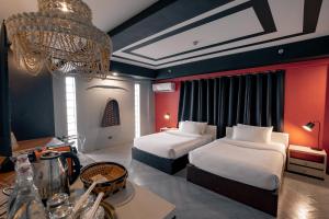 马尼拉Havitat Boutique Hotel的酒店客房设有两张床和吊灯。