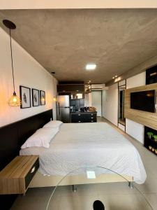 莫索罗Studio Estilo Industrial +Espaço的一间卧室设有一张大床和一张玻璃桌