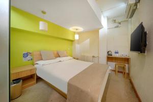 哈尔滨哈尔滨哈什国际青年旅舍哈尔滨西站店的卧室配有白色的床和绿色的墙壁