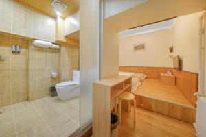 哈尔滨哈尔滨哈什国际青年旅舍哈尔滨西站店的浴室配有卫生间、盥洗盆和浴缸。