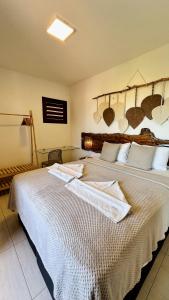 弗雷谢拉斯Apê Jardins的一间卧室配有一张大床和毛巾