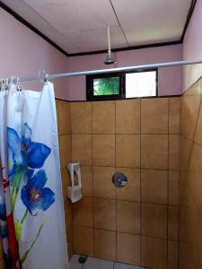 托尔图格罗Chinitas Eco Lodge的浴室设有蓝色花帘淋浴