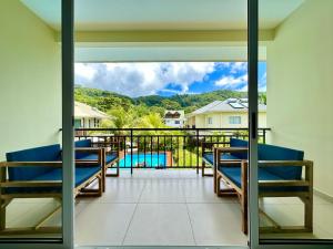 马埃岛The Seaboards Apartments Seychelles的阳台配有椅子,享有游泳池的景色