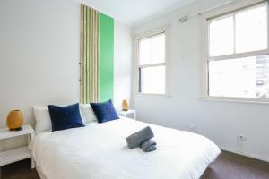 悉尼Superb 2 Bedroom House Darlinghurst 2 E-Bikes Included的卧室配有带蓝色枕头的大型白色床