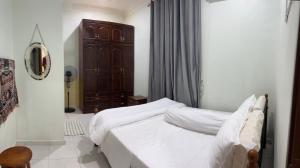 MerlimauMutiara Villa Homestay - Comfort Away From Home的卧室配有白色的床和木制橱柜。