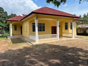 MerlimauMutiara Villa Homestay - Comfort Away From Home的红色屋顶的黄色小房子