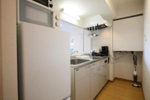 札幌AMS TOWER 806的厨房配有白色橱柜和水槽