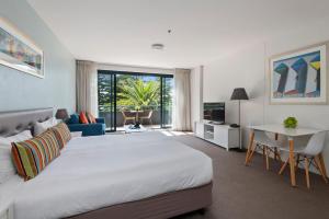 克罗纳拉奎斯特克鲁海滩酒店的卧室配有一张白色的大床和一张桌子