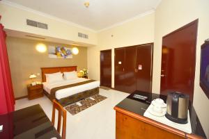 沙迦那约姆阿尔埃玛拉特酒店的配有一张床和一张书桌的酒店客房