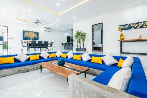拉威海滩Mango Hill Residence的客厅配有蓝色沙发及黄色枕头