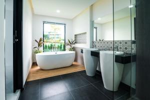 拉威海滩Mango Hill Residence的浴室配有两个盥洗盆和浴缸。