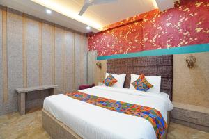 KakarmathaFabHotel RS Residency的一间卧室设有一张大床和色彩缤纷的墙壁