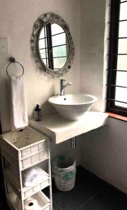 德班Sherwood Garden Cottage的一间带水槽和镜子的浴室