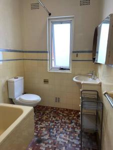 悉尼3 BDR house close to train station, airport & City的浴室配有卫生间、盥洗盆和浴缸。