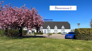 弗兰奎维尔-圣皮尔鲁昂庭院酒店的停在一座有花树的建筑前面的蓝色汽车