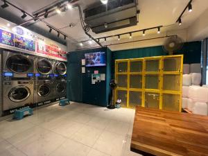 丹绒亚路M Suite Homestay, Aeropod Sovo Kota Kinabalu的洗衣房配有两台洗衣机和黄色门
