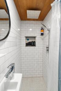 安吉利斯港Blue Moon Tiny House, Sauna,ht的带淋浴和盥洗盆的白色瓷砖浴室
