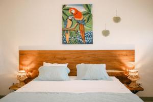El Paredón Buena VistaVilla Makai 2 Blue的卧室配有一张大床,墙上挂有鹦鹉画