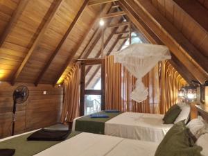 哈伯勒内Habarana New Star Homestay的一间卧室设有两张床,阁楼上设有窗户。