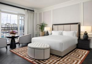 开普敦Cape Grace, A Fairmont Managed Hotel的一间带一张白色大床的卧室和一个阳台