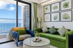 富国Rosie Hillside Seaview Phu Quoc Apartment的客厅配有绿色沙发和桌子