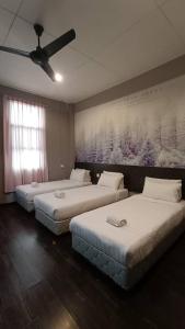 昆达桑Jabez Resort Kundasang的一间设有三张床的客房,墙上挂着一幅画