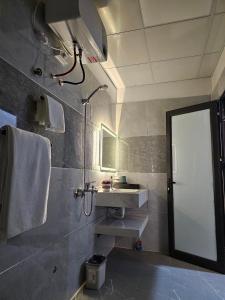 海阳Milano Hotel的浴室配有盥洗盆和带镜子的淋浴