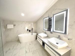 莱基Riviera Hotel, Apartments & Resorts的白色的浴室设有浴缸和水槽。