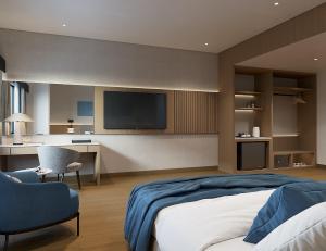 帕卢ASTON Palu Hotel & Conference Center的一间卧室配有一张床,墙上配有电视