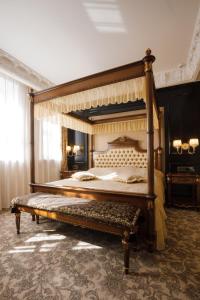 第聂伯罗阿克赛尔霍夫精品酒店的大卧室设有一张带长凳的天蓬床