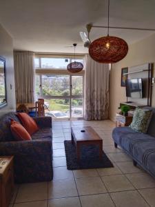 乌姆德洛蒂106 Umdloti Resort的客厅配有沙发和桌子