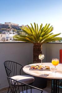 雅典Athens Ivy Suites的一张桌子,上面放着一盘食物和酒杯
