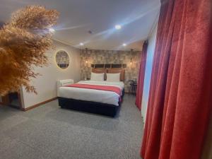 第比利斯TownHouse Tbilisi Boutique Hotel的一间卧室配有一张带红色窗帘的大床