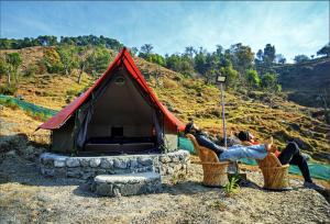 比尔瓦Crazy Cub Camp - A Luxury Campsite的两人坐在帐篷前的椅子上