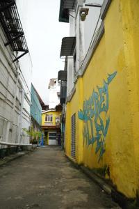 康提City View Hostel的黄色建筑一侧的一条带有涂鸦的小巷