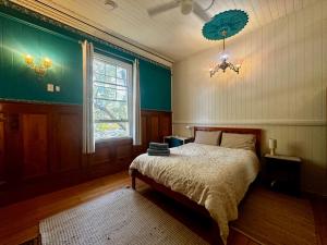 布里斯班Minto Accommodation Brisbane的一间卧室设有一张床、一个窗户和一个吊灯。