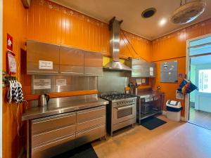 布里斯班Minto Accommodation Brisbane的厨房配有橙色墙壁和不锈钢用具